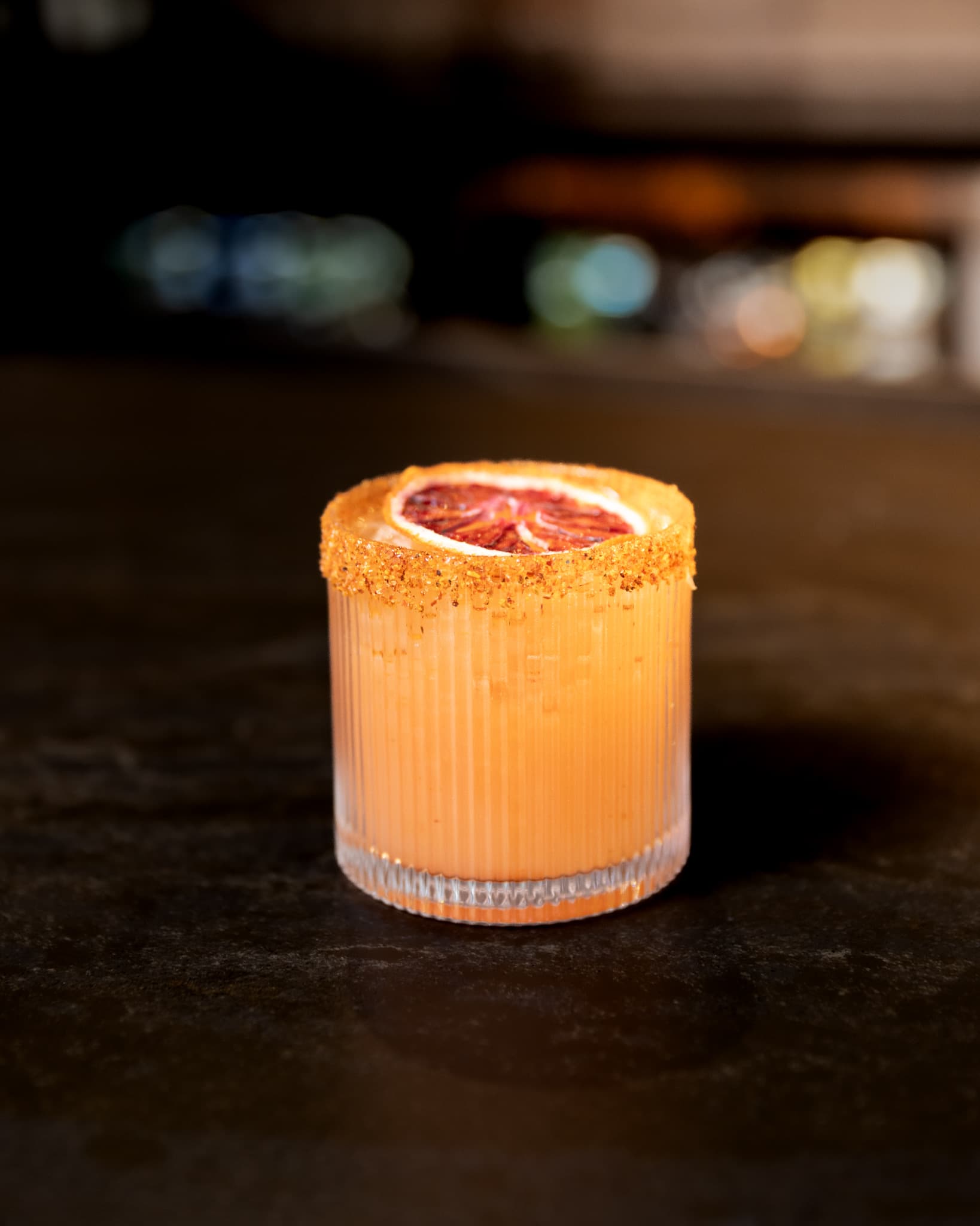 A blood orange cocktail with a chili salt rim on the bar at CHR Steak in Gainesville, Georgia