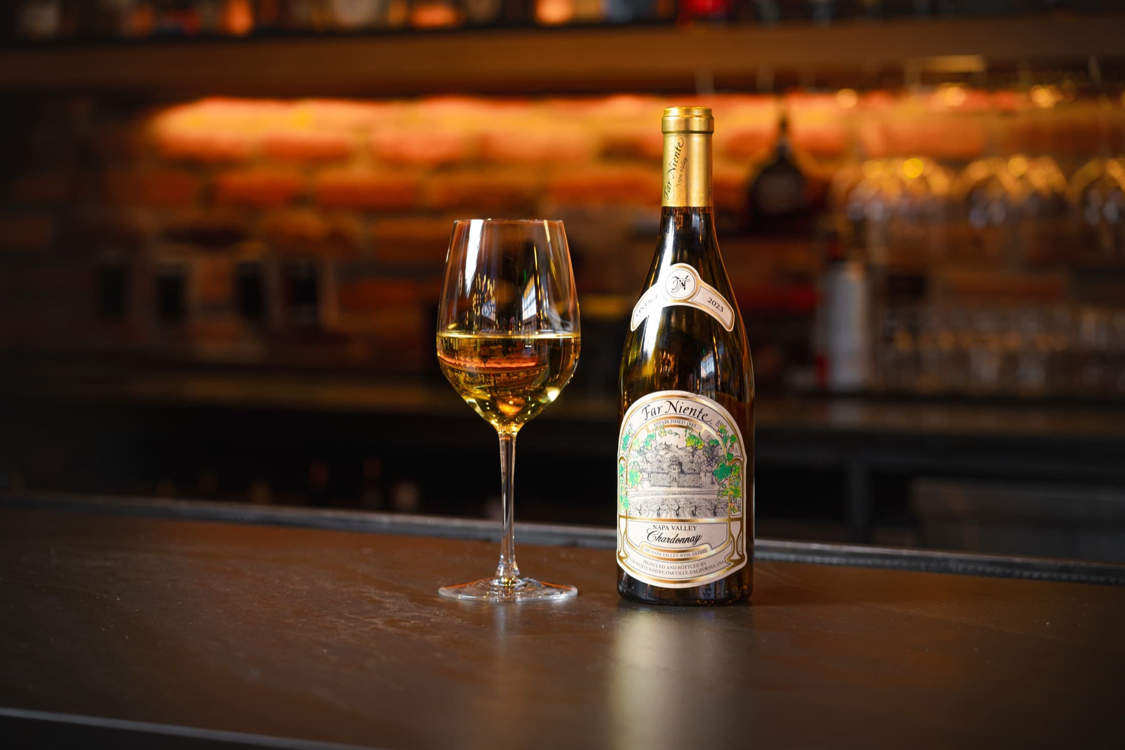 A bottle of Far Niente Chardonnay and a poured glass on the CHR Steak bar