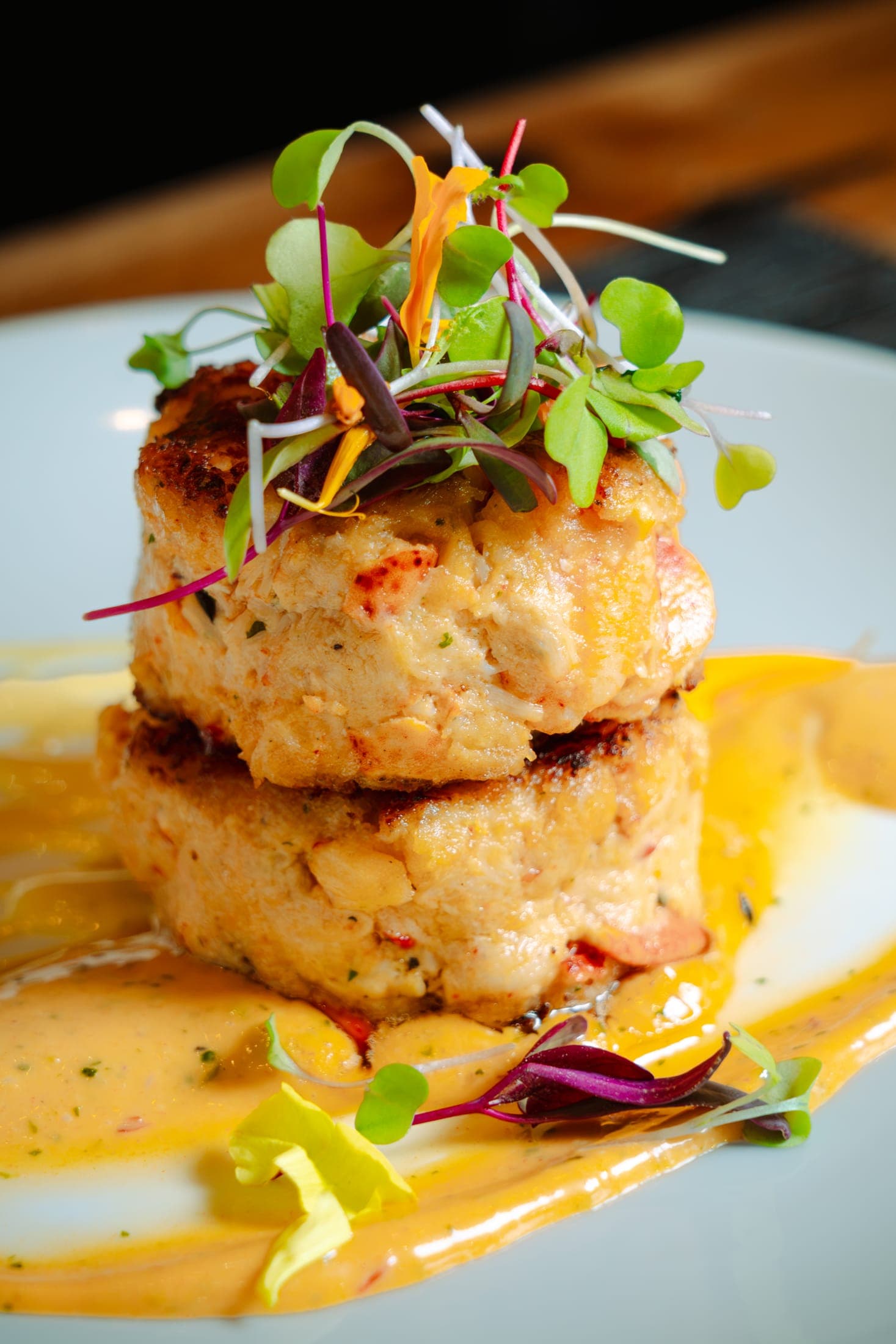 Stacked lobster cakes with microgreens and aioli at CHR Steak