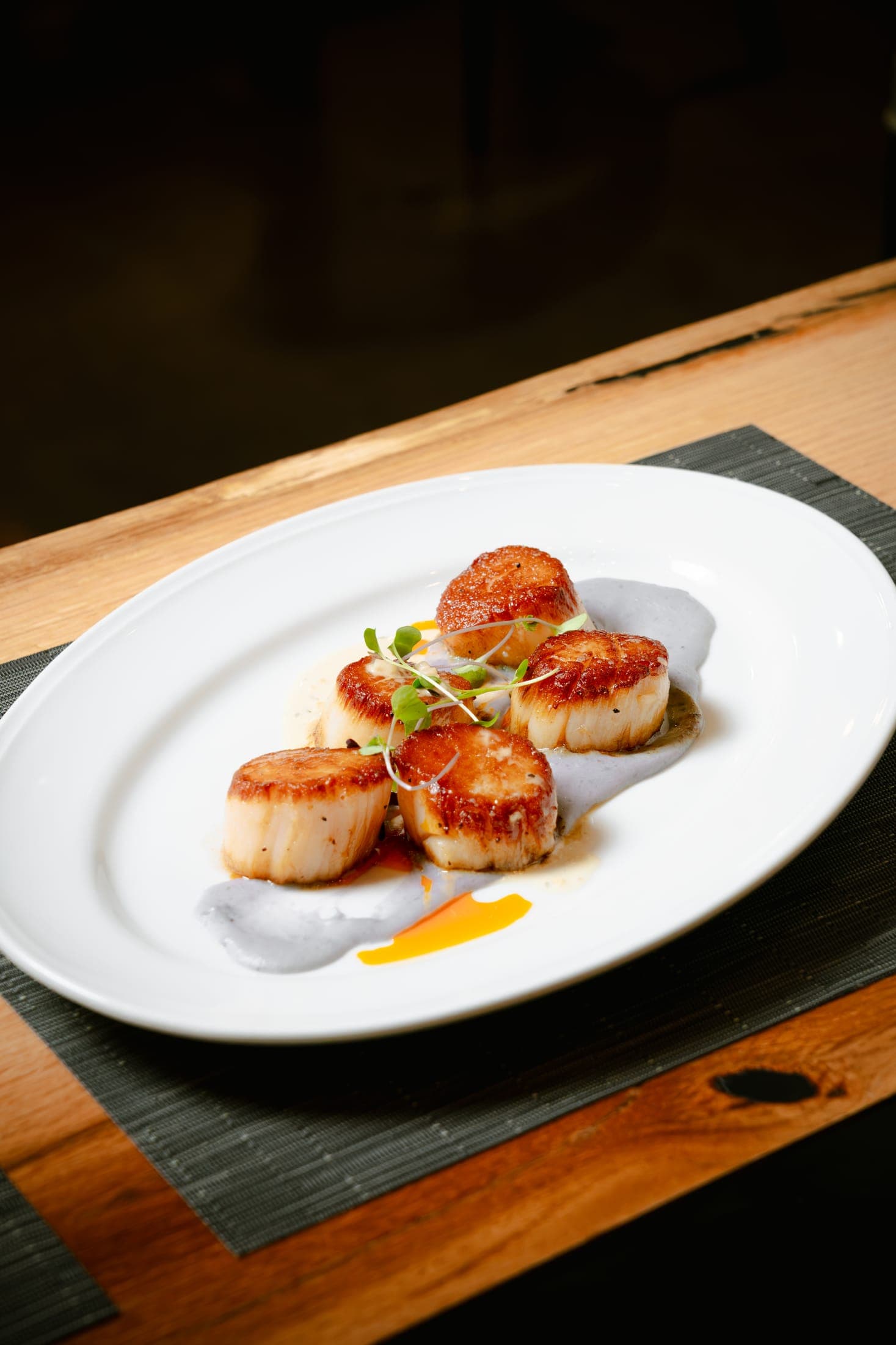 Seared scallops with microgreens plated at CHR Steak
