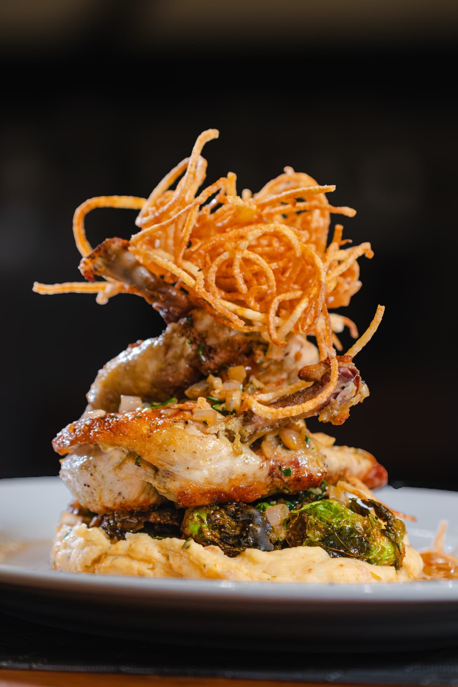 Sous vide chicken over mash with brussels sprouts and a nest of crispy shoestrings at CHR Steak